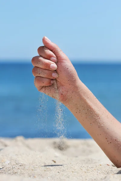 Hand kastar sand på stranden — Stockfoto