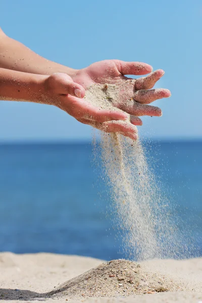 Hand kastar sand på stranden — Stockfoto