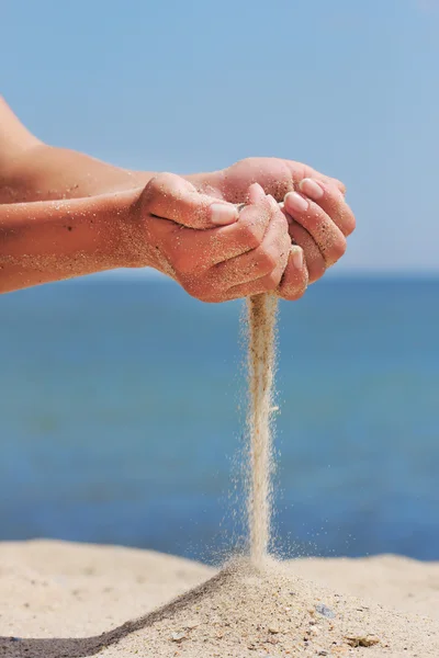 Mão joga areia na praia — Fotografia de Stock