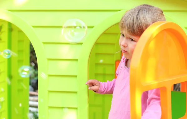 Petite fille avec une maison de jeux pour enfants — Photo