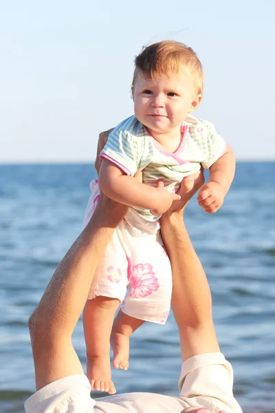 Padre con una pequeña hija en la orilla del mar Imagen de archivo