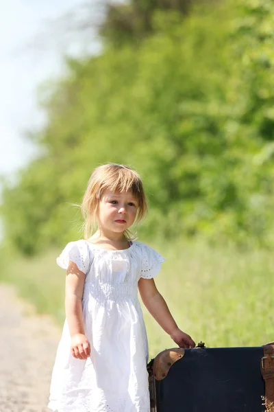 Bella bambina con una valigia — Foto Stock