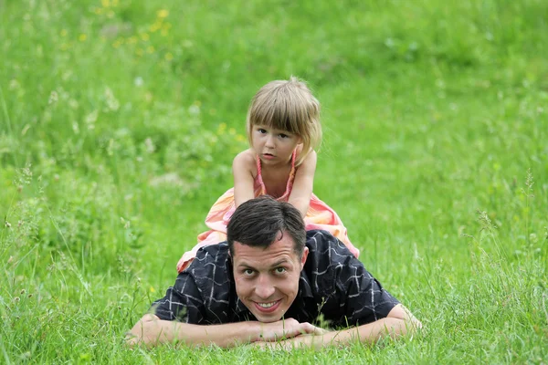 Liten flicka spelar med pappa i naturen — Stockfoto
