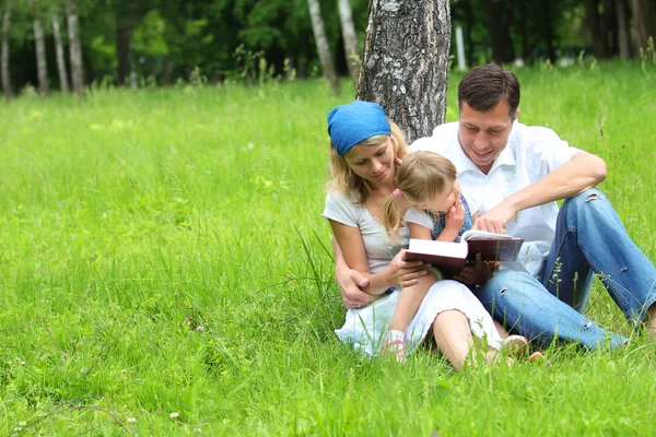 Семья с маленькой дочерью читает Библию — стоковое фото