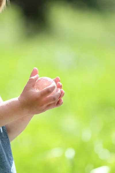 Glazen bol in de handen van kinderen — Stockfoto