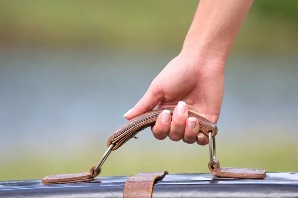 Hands of a woman with a suitcase — Stock Photo, Image