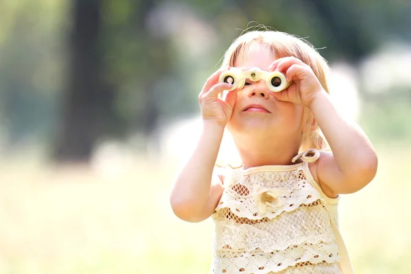 Beautiful young girl on nature with binoculars — Stock Photo, Image