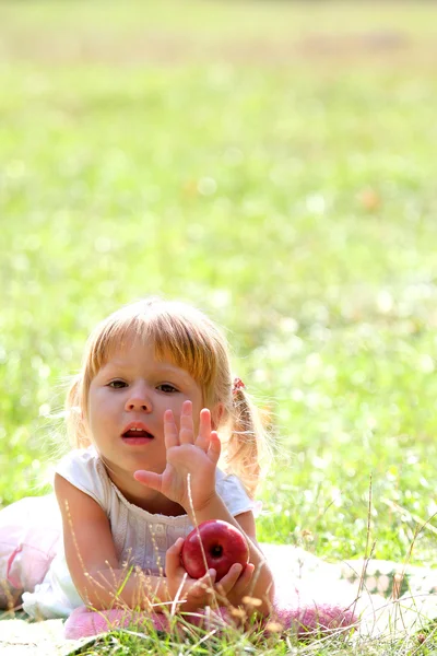 Beautiful little girl outdoors with apple — Stock Photo, Image