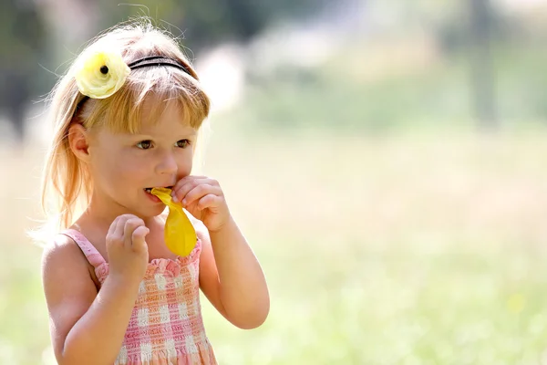 Schönes kleines Mädchen in der Natur mit Luftballons — Stockfoto