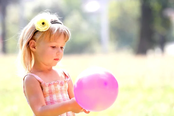 Hermosa niña en la naturaleza con globos — Foto de Stock