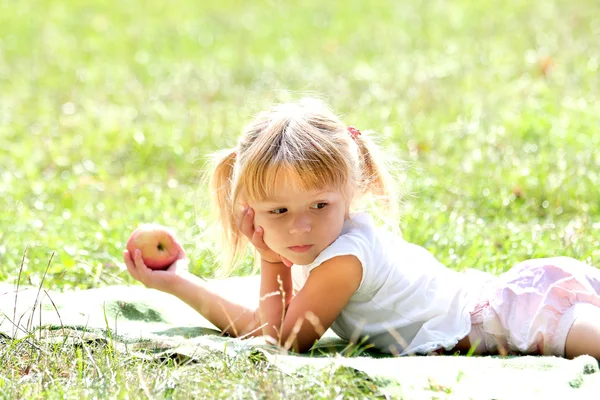 Beautiful little girl outdoors with apple — Stock Photo, Image