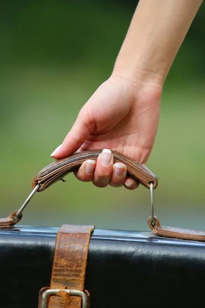 Händerna på en kvinna med en resväska — Stockfoto