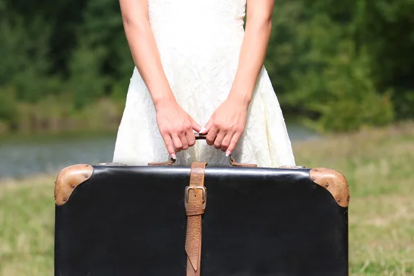 Hands of a woman with a suitcase — Stock Photo, Image