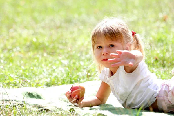 Beautiful little girl outdoors with apple — Stock Photo, Image