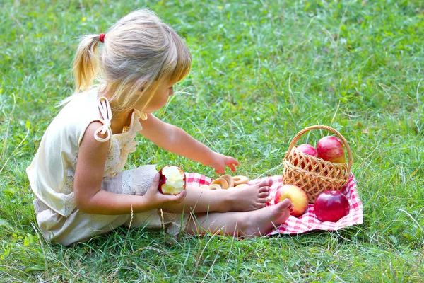 Beautiful little girl outdoors with apple — Stock Photo, Image