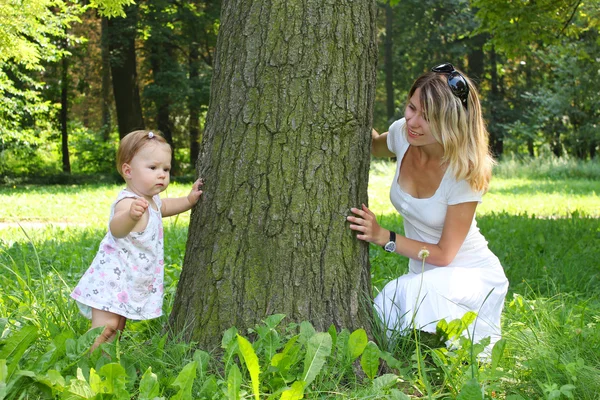 Mamãe e sua filhinha perto da árvore — Fotografia de Stock