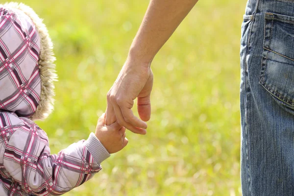 Eltern halten die Hand eines kleinen Kindes — Stockfoto