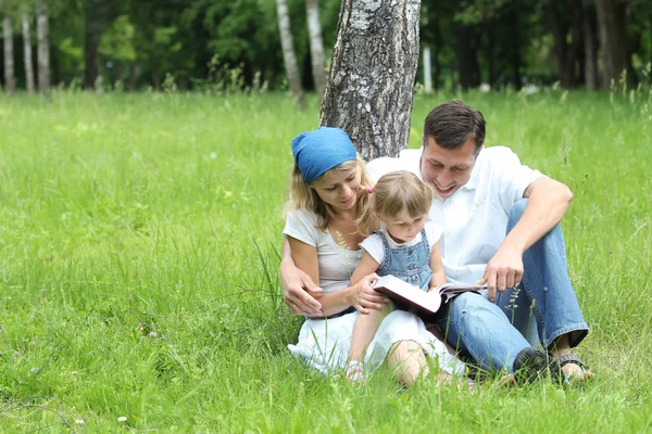 Familia joven leyendo la Biblia — Foto de Stock