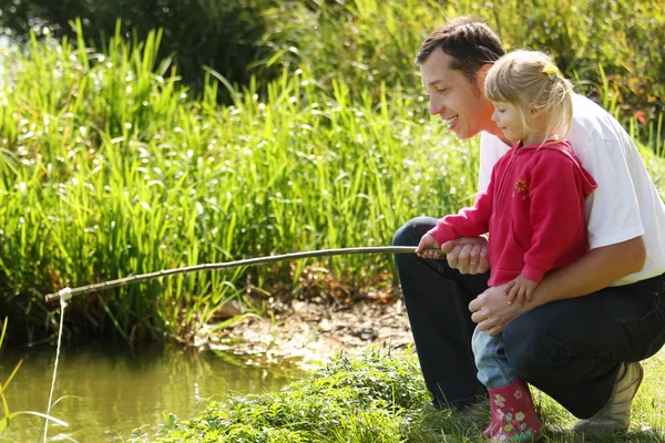 Papá y su hija pequeña cerca de un lago — Foto de Stock