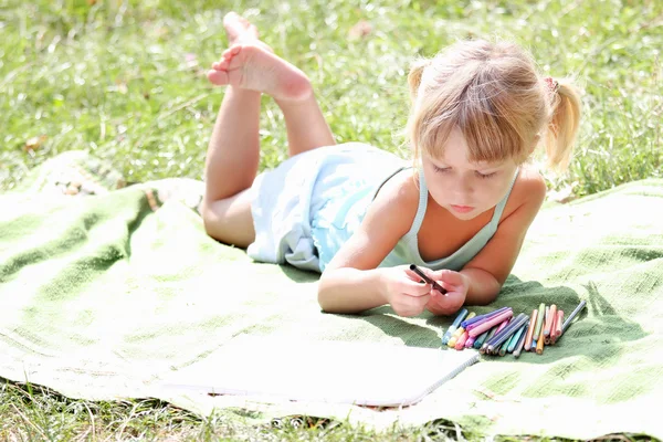 Beautiful little girl drawing on nature — Stock Photo, Image