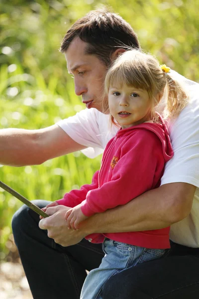 Papá y su hija pequeña cerca de un lago — Foto de Stock