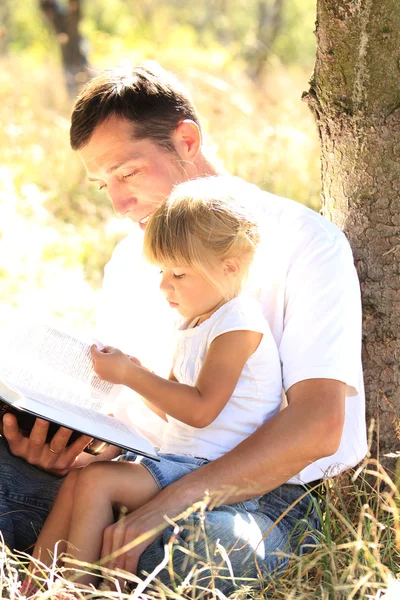 Отец со своей маленькой дочерью читает Библию — стоковое фото