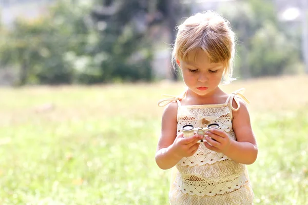 Beautiful young girl on nature with binoculars — Stock Photo, Image