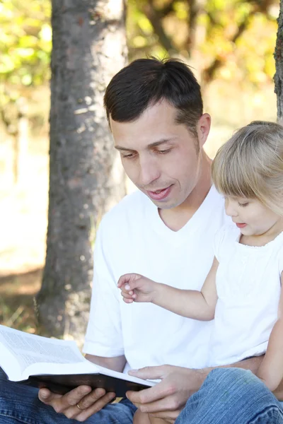 Babasının küçük kızı ile İncil okur — Stok fotoğraf