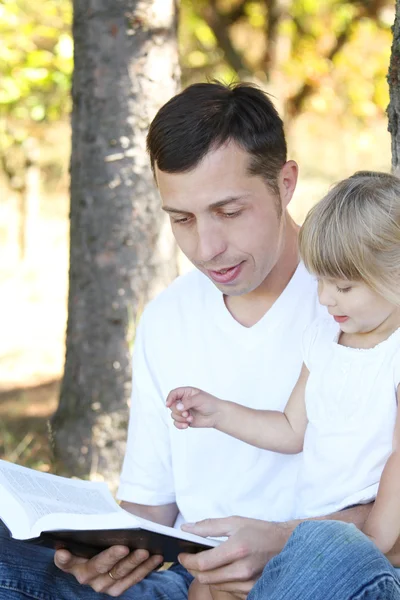 Father with his little daughter reads the Bible — Stock Photo, Image