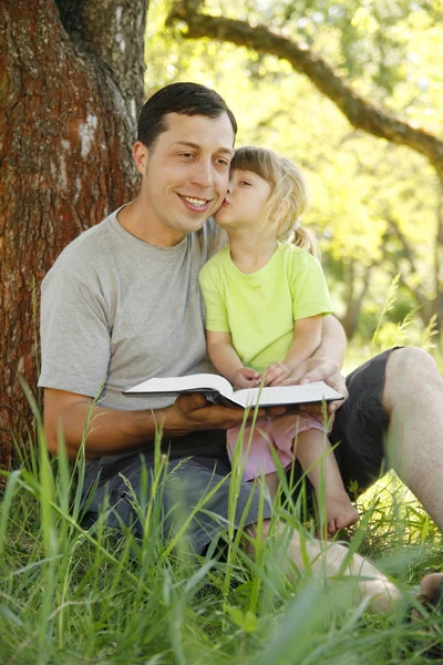 Father with his little daughter reads the Bible — Stock Photo, Image