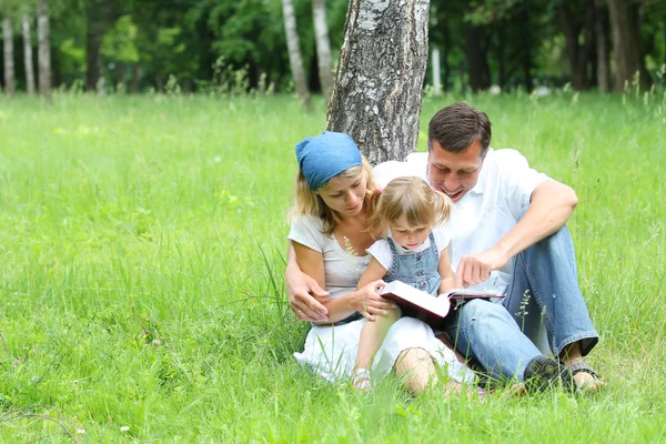 Jonge gezin lezen van de Bijbel — Stockfoto