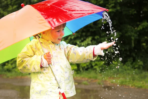 Little girl with an umbrella in the rain — Stock Photo, Image