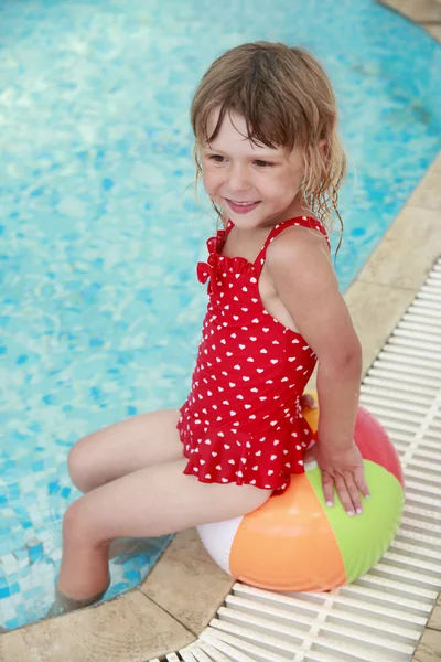 Klein meisje in het zwembad water met een bal — Stok fotoğraf