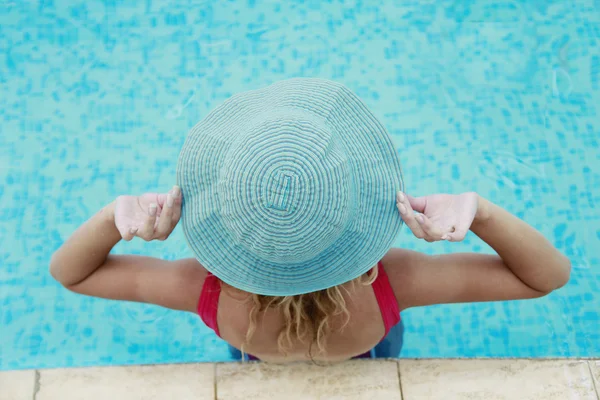 Chica en un sombrero en la piscina de agua —  Fotos de Stock