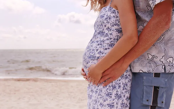 Coppia incinta innamorata sulla spiaggia — Foto Stock