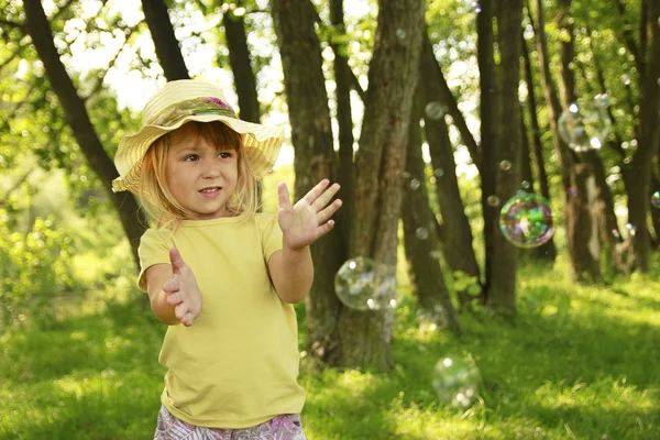 Vacker liten flicka i en hatt på natur — Stockfoto