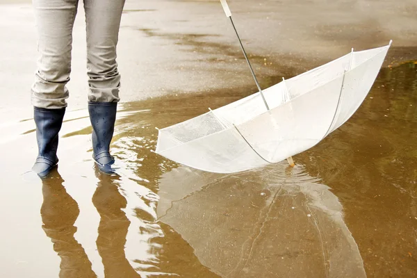 A man with an umbrella in his boots and puddle — Stock Photo, Image