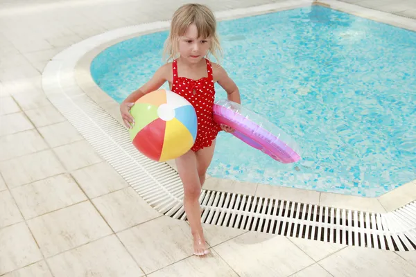 Klein meisje in het zwembad water met een bal — Stockfoto