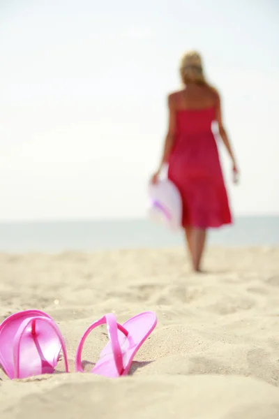 Girl with slippers on a beach — Stock Photo, Image