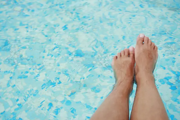 Vrouwelijke benen in het zwembad water — Stockfoto