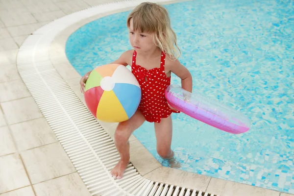 Petite fille dans la piscine d'eau avec une balle — Photo