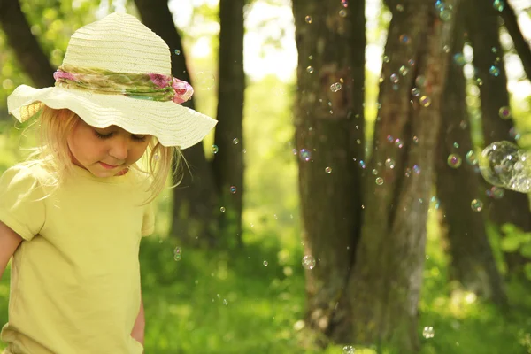 Vacker liten flicka i en hatt på natur — Stockfoto