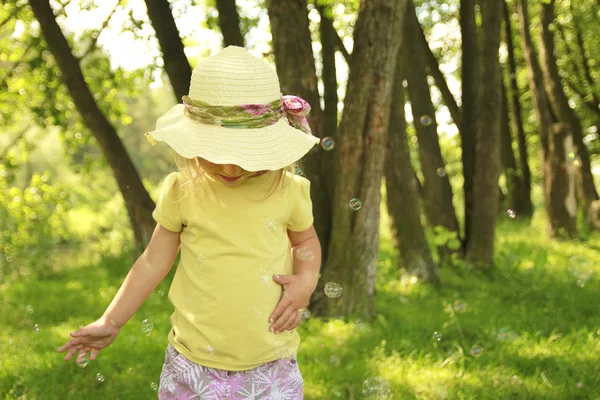 Красивая маленькая девочка в шляпе на природе — стоковое фото