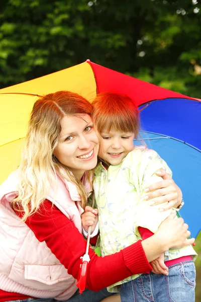 Little girl with an umbrella in the rain with mom — Stock Photo, Image