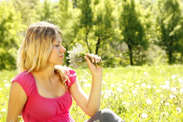Girl with a bouquet of flowers in nature — Stock Photo, Image