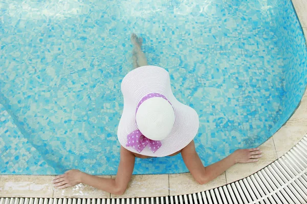 Dziewczyna w kapeluszu w basenie woda — Zdjęcie stockowe