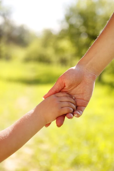 Eltern halten die Hand eines kleinen Kindes — Stockfoto