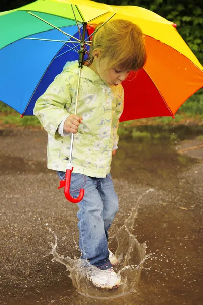 Flicka med ett paraply i regnet — Stockfoto