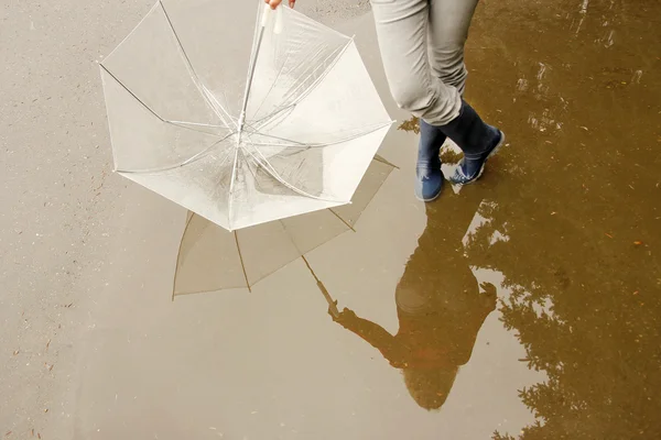 一男子用一把雨伞在他的靴子和水坑 — 图库照片