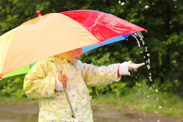 Little girl with an umbrella in the rain — Stock Photo, Image